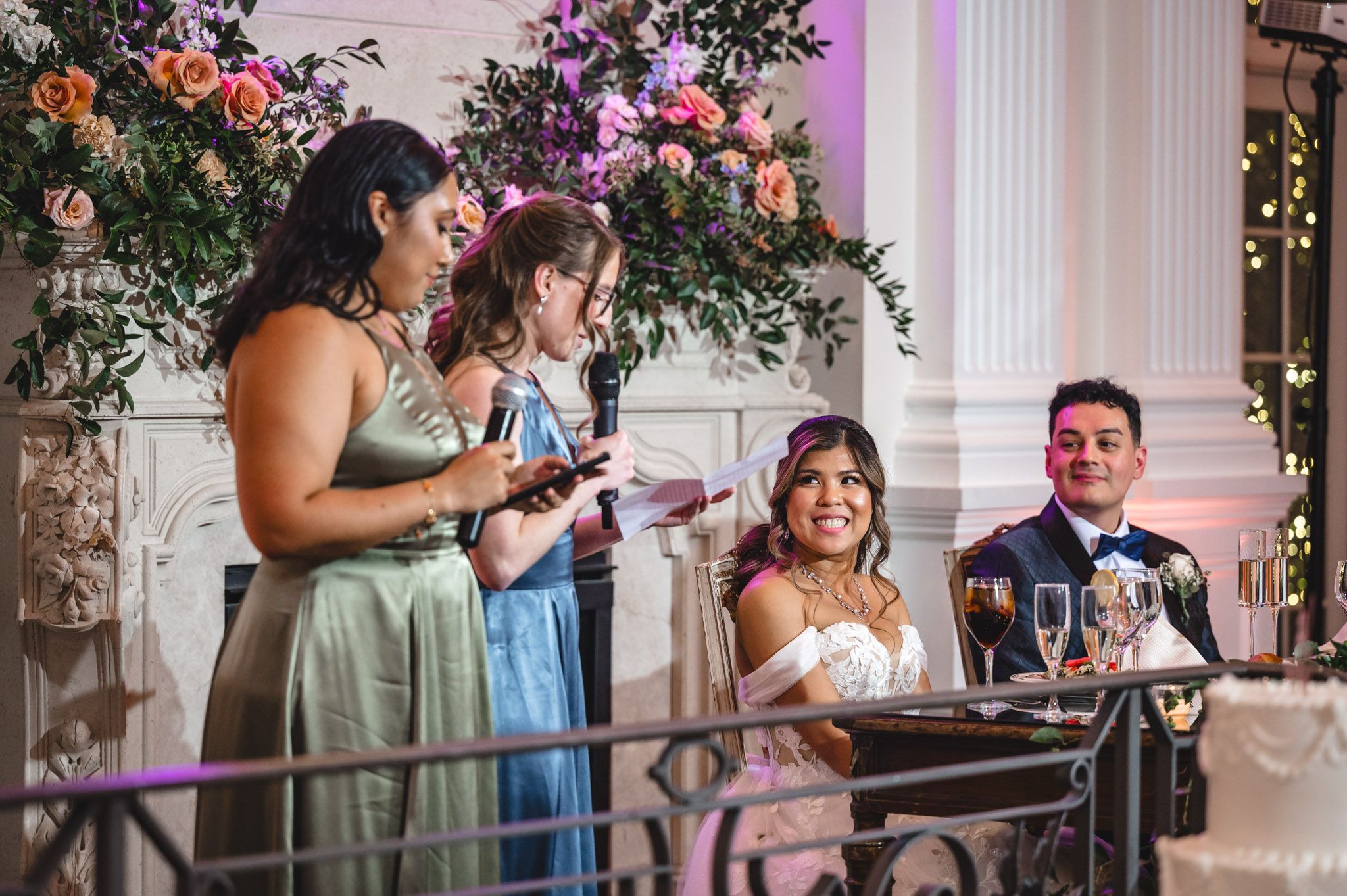 Wedding guests give heartfelt toasts during an elegant reception decorated with floral arrangements.