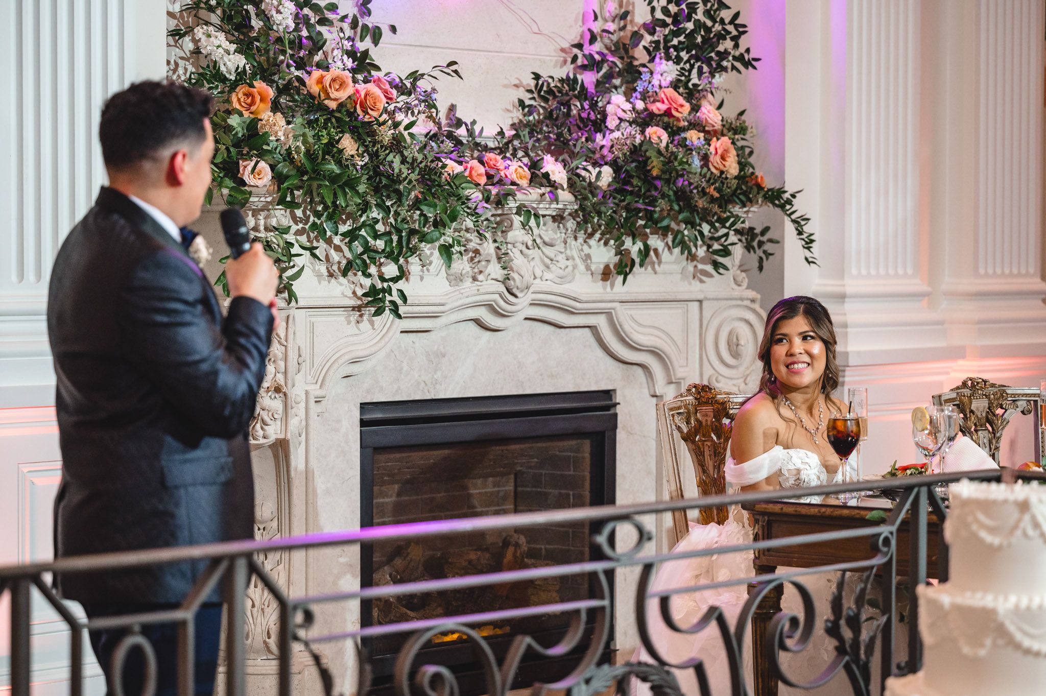 Emotional wedding speeches being delivered during an elegant reception with floral decor.
