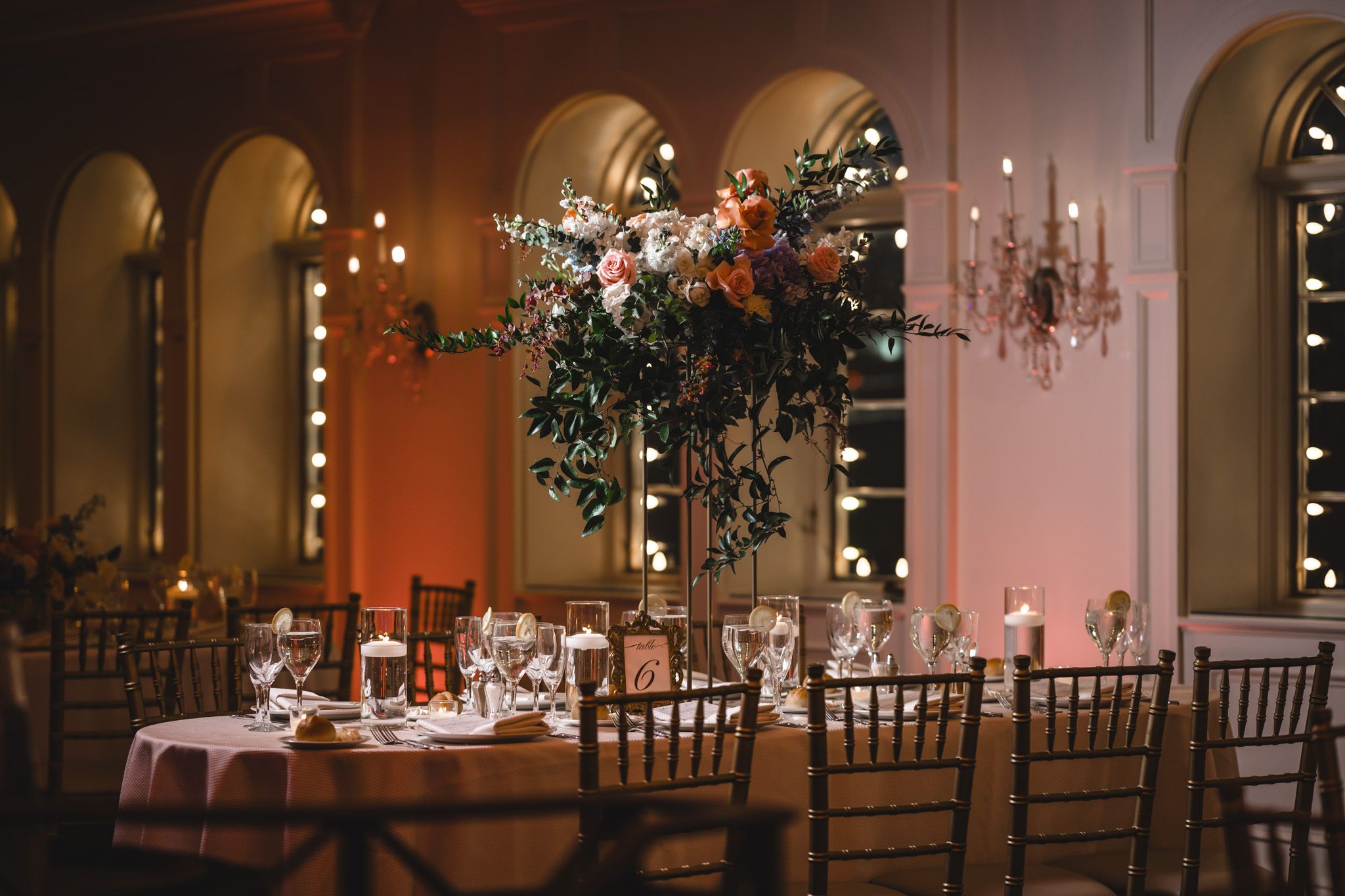 Romantic wedding reception venue with string lights and Chiavari chairs creating an elegant ambiance.