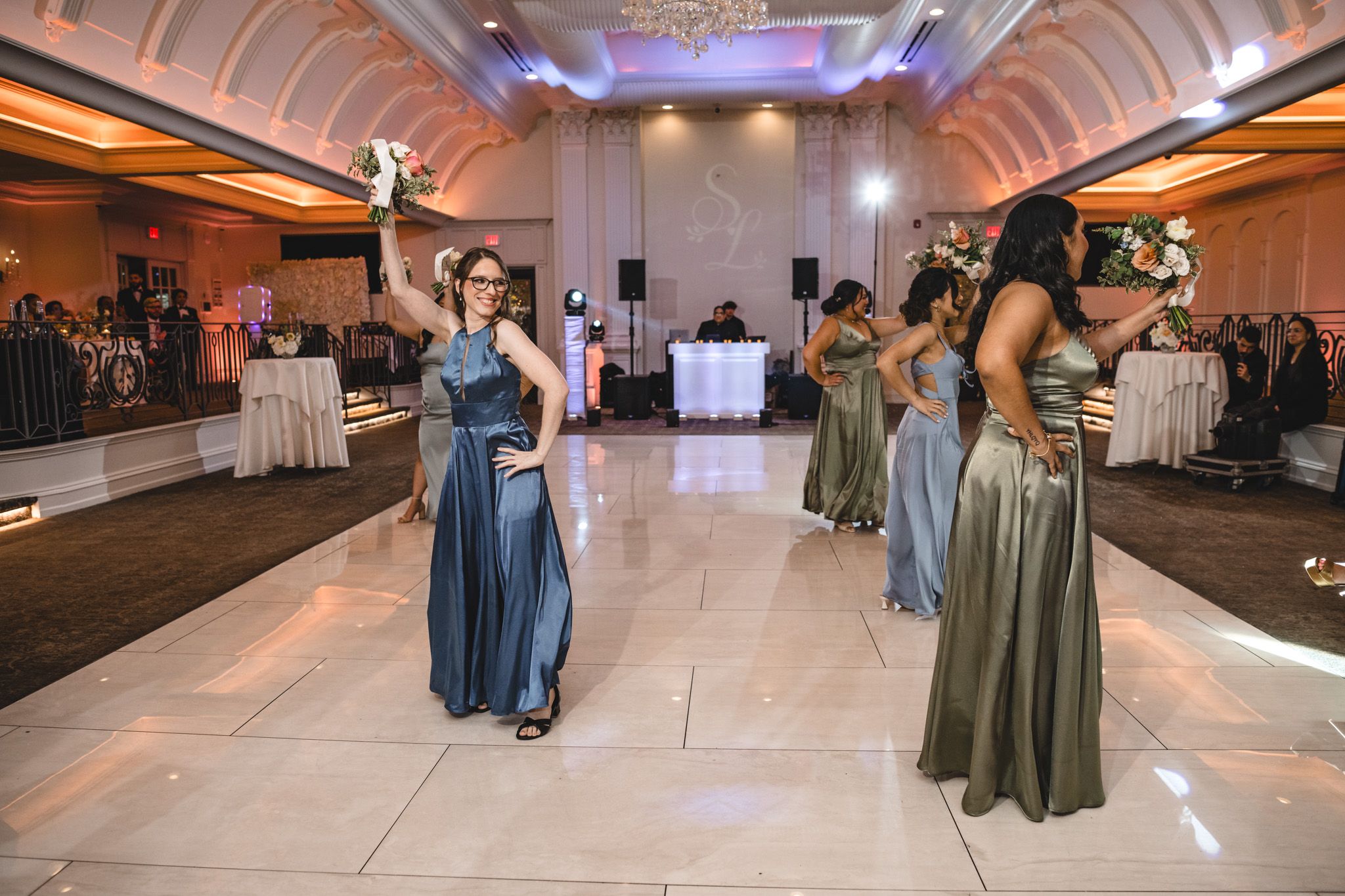Spacious ballroom with vaulted ceiling and white dance floor set up for wedding reception.