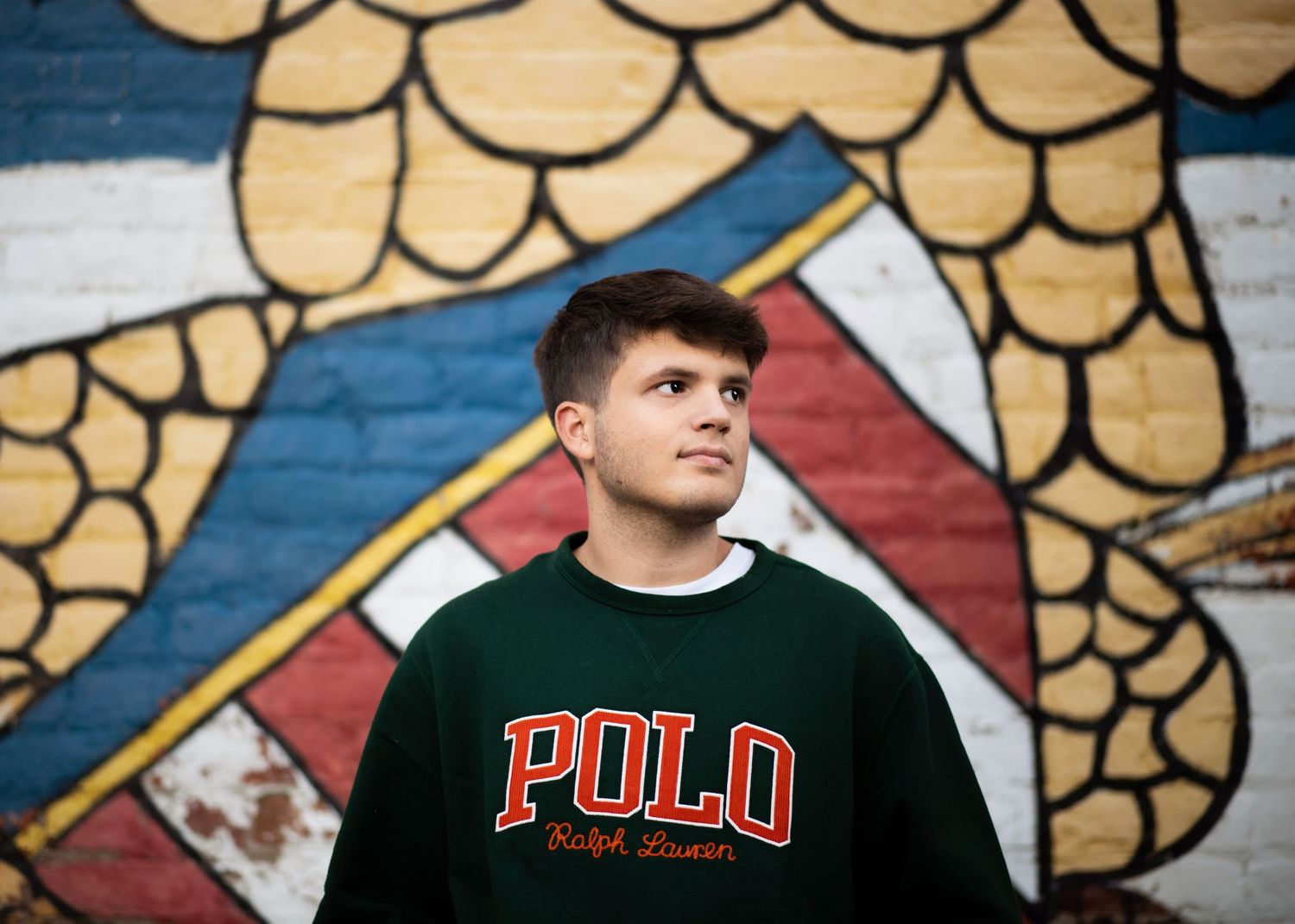 American mural behind guy wearing a polo shirt giving a Tommy Hilfiger feel to the image