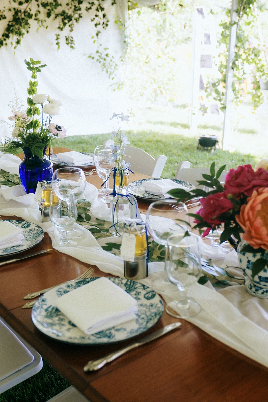 Elegant table setting with floral china plates and colorful flower arrangements.