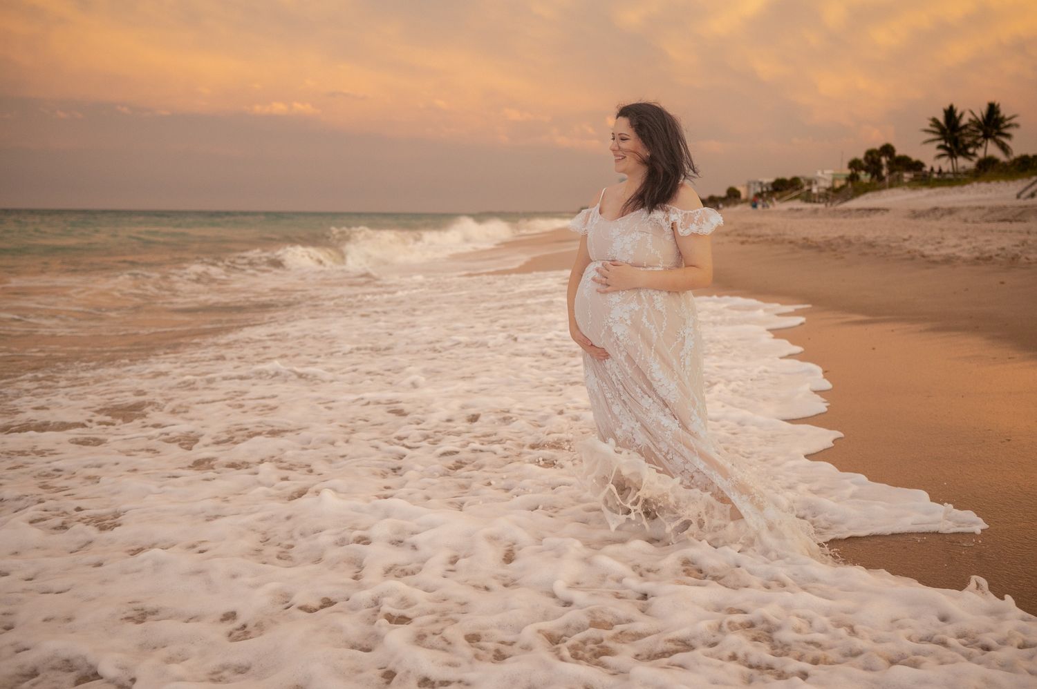 Maternity session pregnant mother standing waves on beach looking out into the sunset Melbourne Cocoa Beach Vero Florida Brevard County