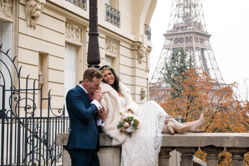 romantic moment by the Eiffel tower, a groom kissing the bride's hand, captured by Julien Paris wedding photographer