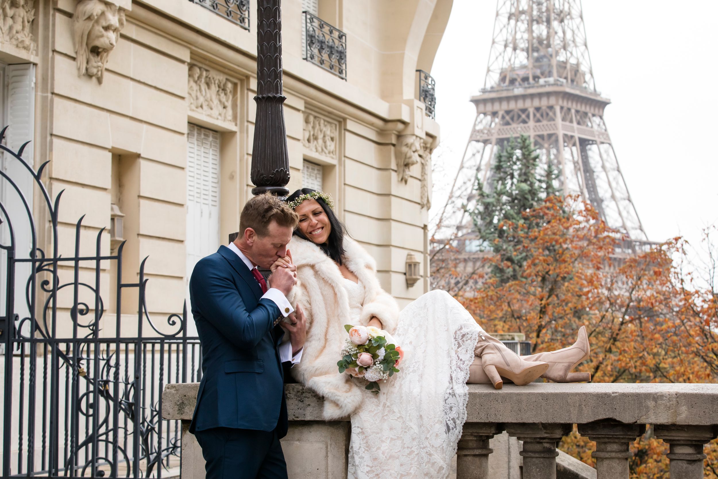 romantic moment by the Eiffel tower, a groom kissing the bride's hand, captured by Julien Paris wedding photographer