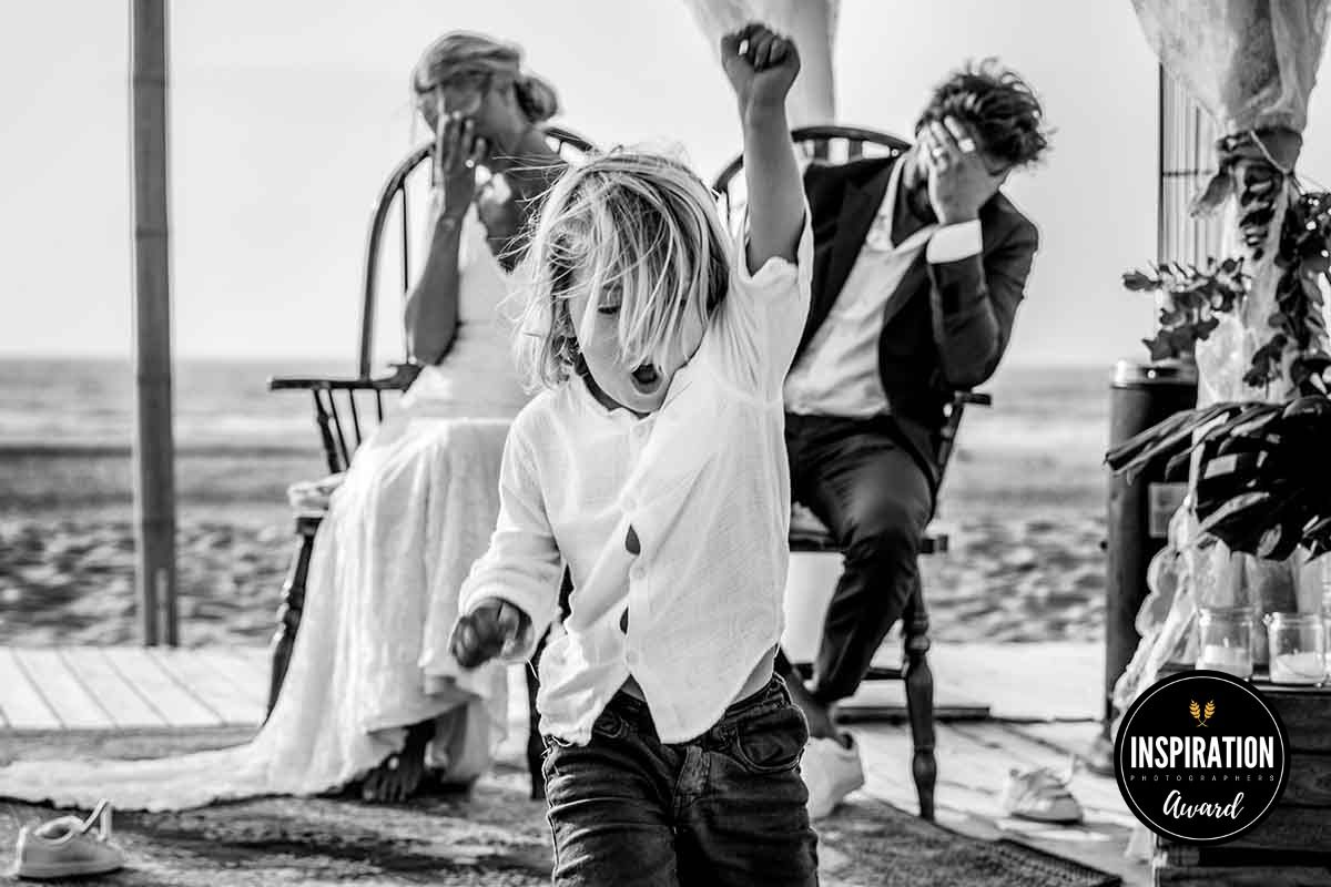 Black and white candid photograph of celebration with dancing and joyful movement.