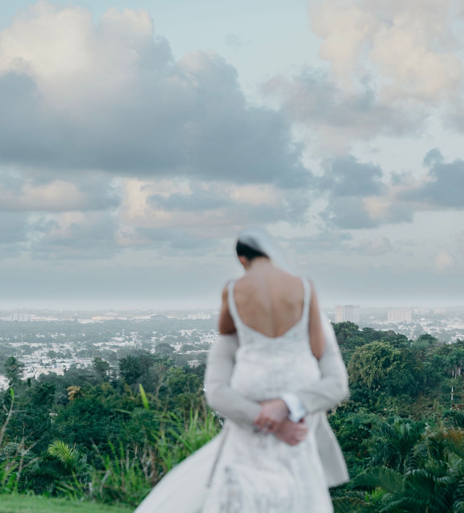 A joyful couple celebrates their beach wedding as guests cheer during a candid romantic moment by the ocean.