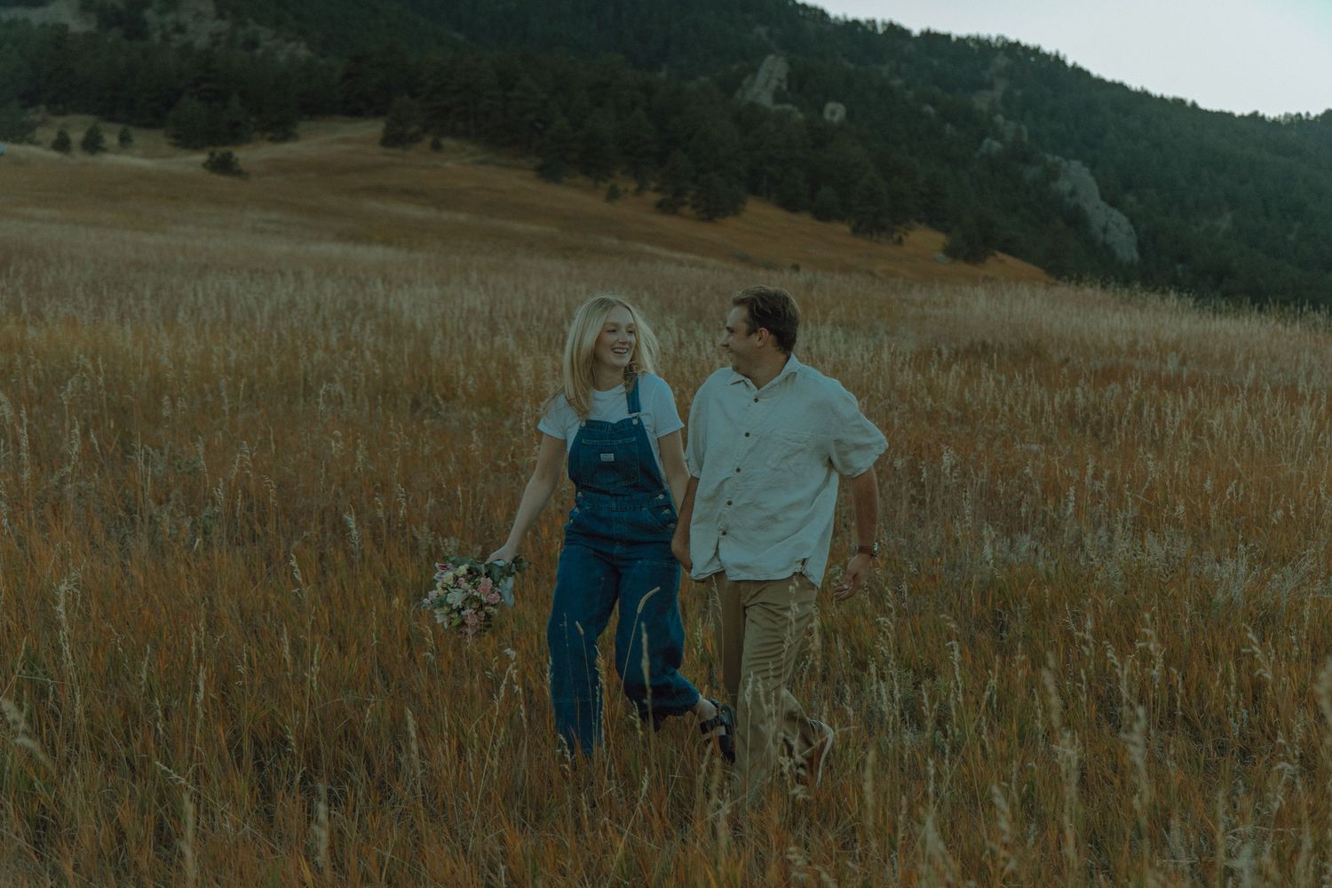 couple running through wheat field