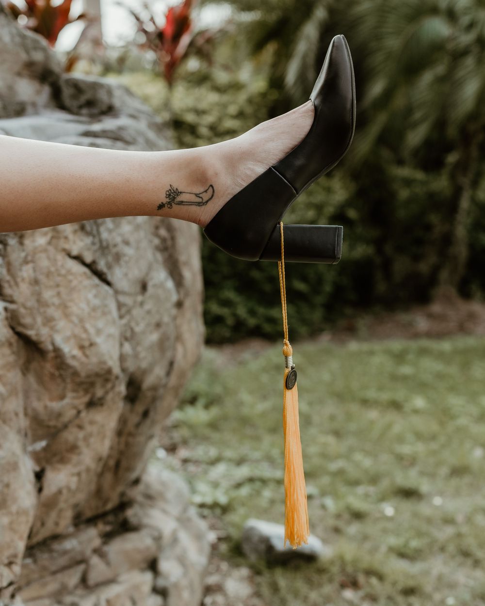 Close-up of graduation tassel and cap against natural outdoor setting.