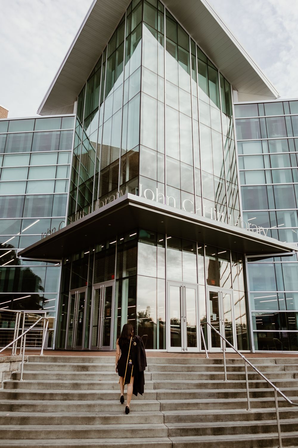 Modern glass building exterior with angular architecture and wide concrete steps.