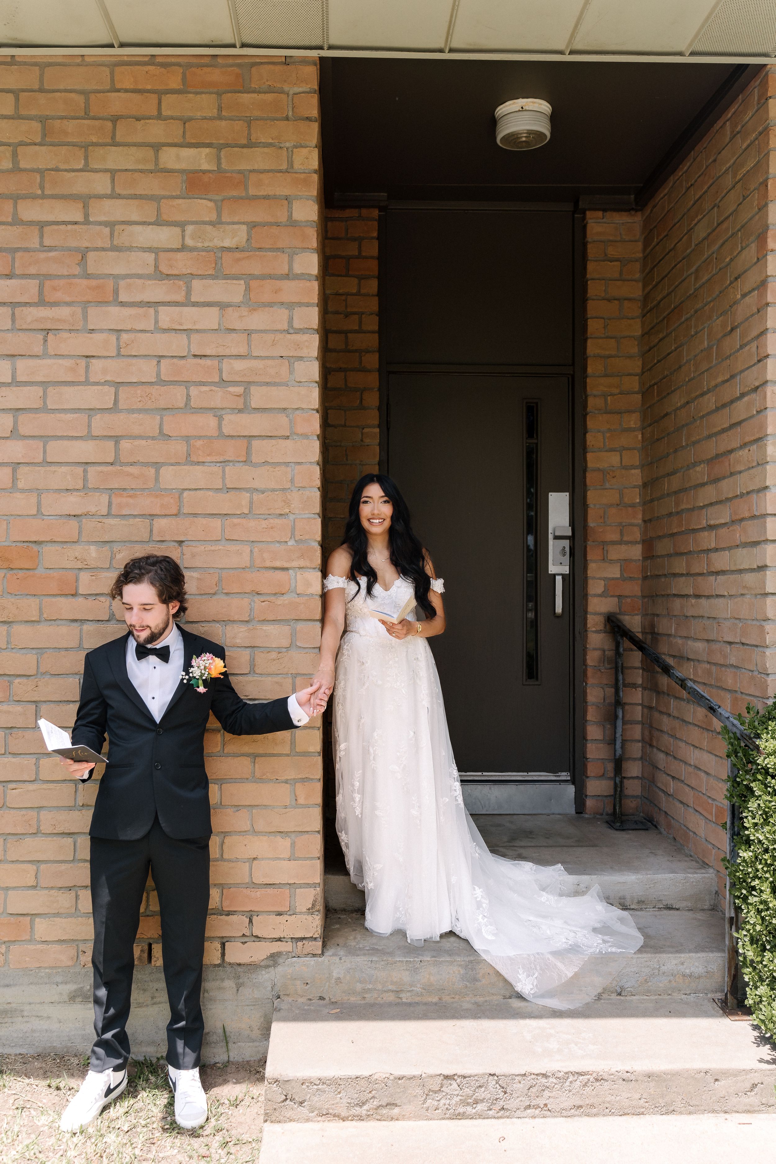 A playful wedding photoshoot sequence showing a couple creating dramatic poses against a brick building entrance.