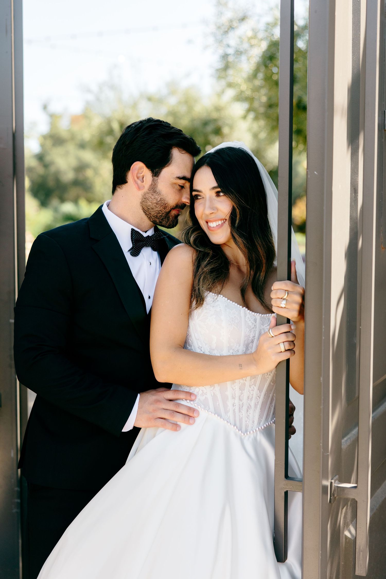 A couple shares tender moments in an elegant columned venue on their wedding day.