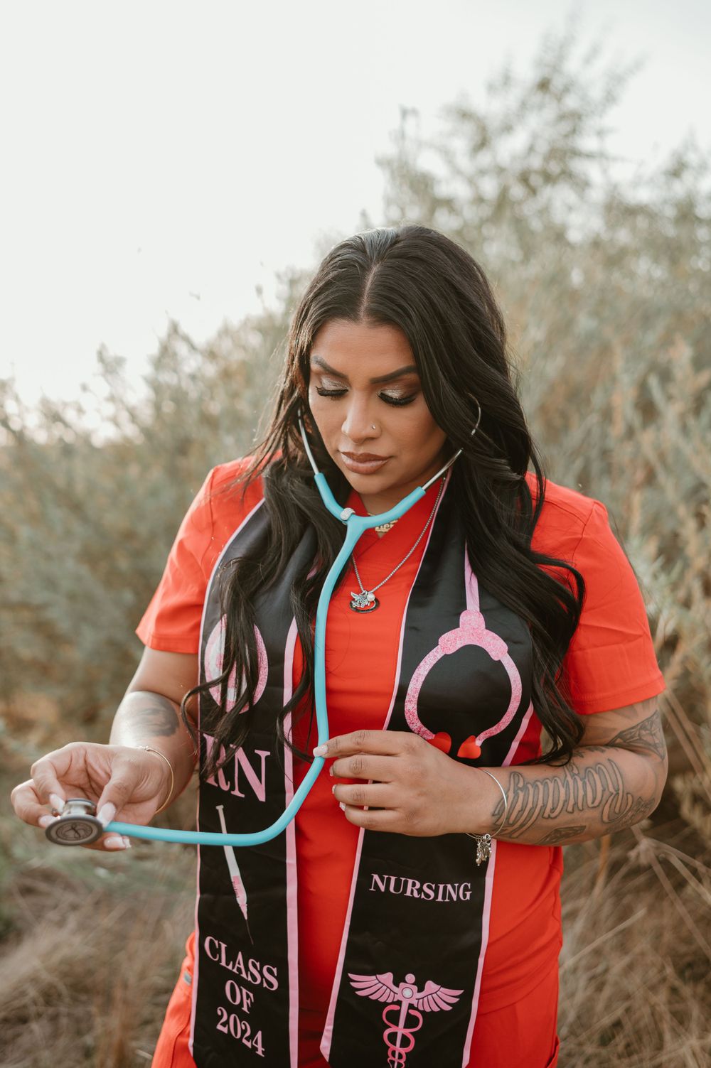 A nursing graduate shows off their stethoscope and Class of 2024 graduation stole.