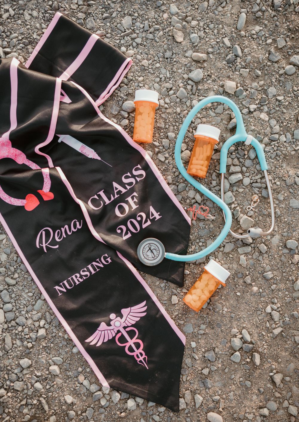 Nursing graduation stole with class of 2024 text displayed with stethoscope and medical props.