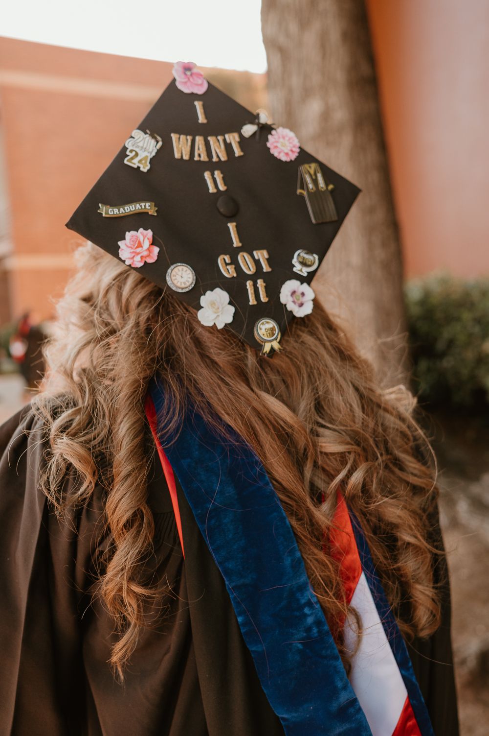 Decorated graduation cap with floral designs and personal messages.