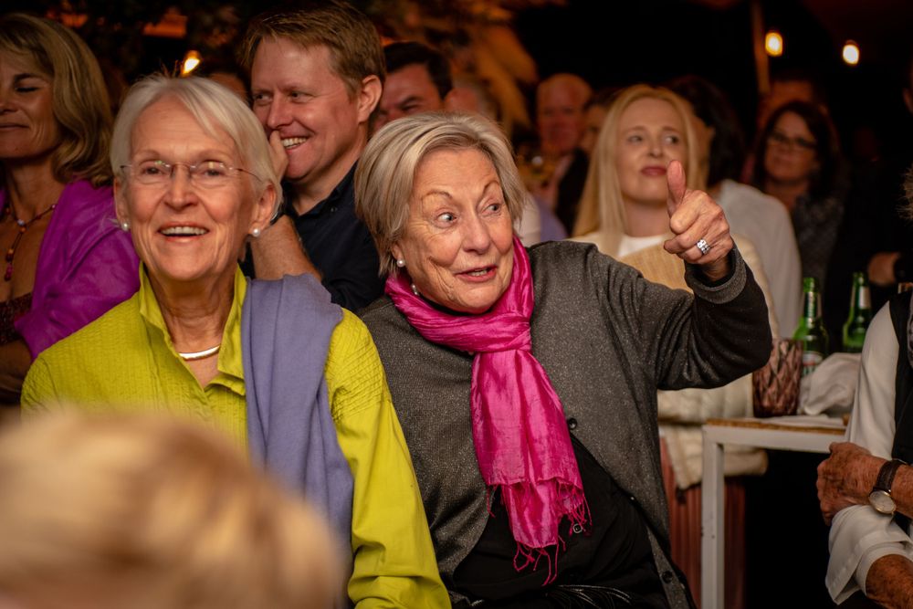 A candid photo of people enjoying the speeches at a photo shoot of a birthday party