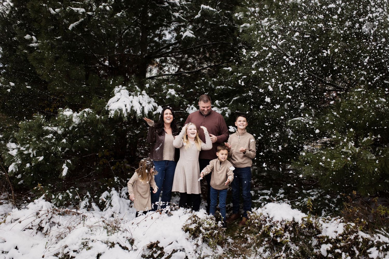 Group of people standing together in a snowy winter landscape surrounded by snow-covered trees.