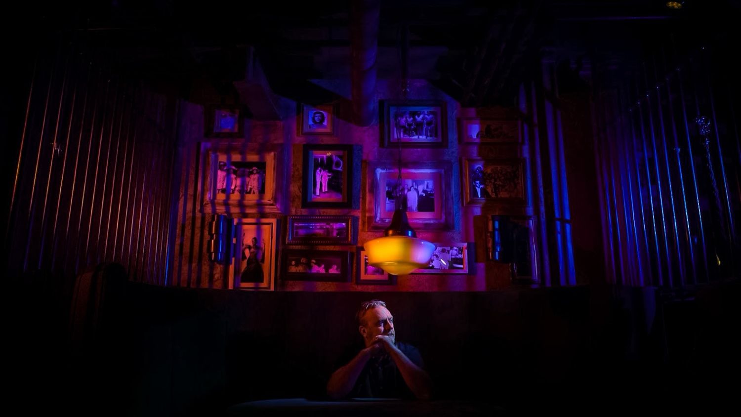 Dramatic stage lighting creates silhouette effect in theatrical performance setting.