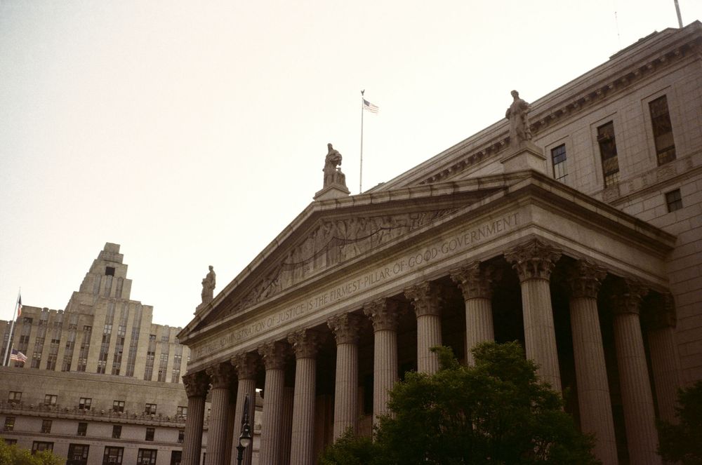 Classical government building with tall Corinthian columns and pediment under an overcast sky.