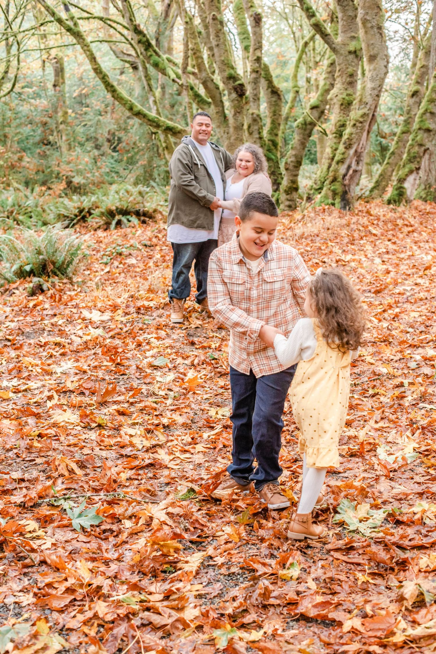 Candid shots of playful interaction among fallen autumn leaves in a wooded setting.