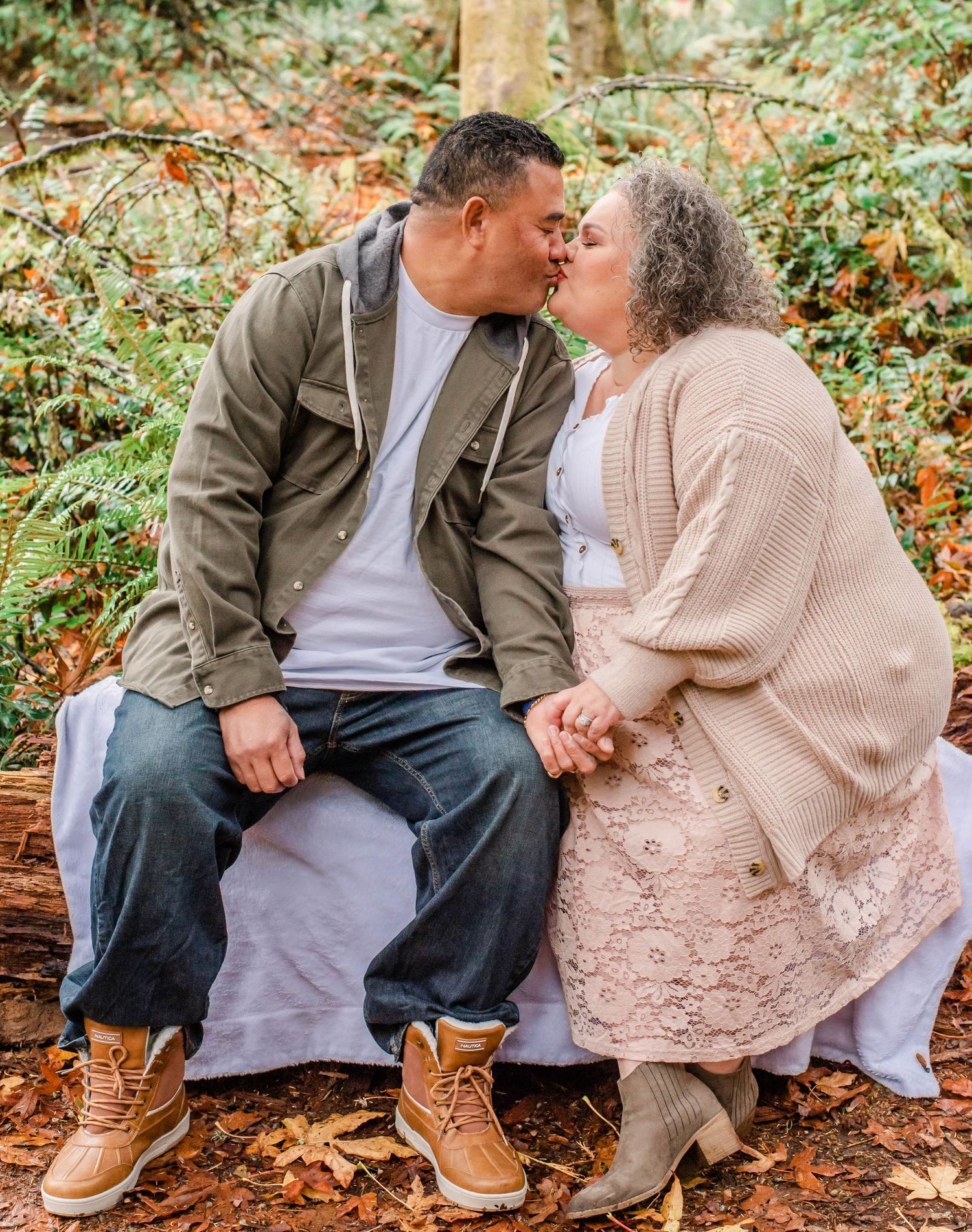 Intimate couple photos on a fallen log surrounded by autumn foliage.