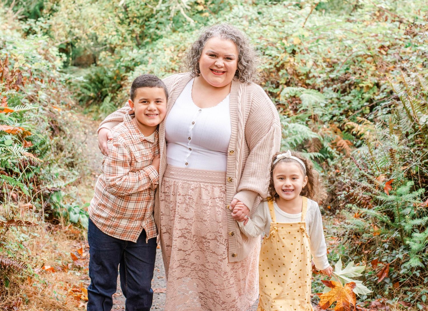 Family group photos in coordinated outfits against lush forest backdrop.