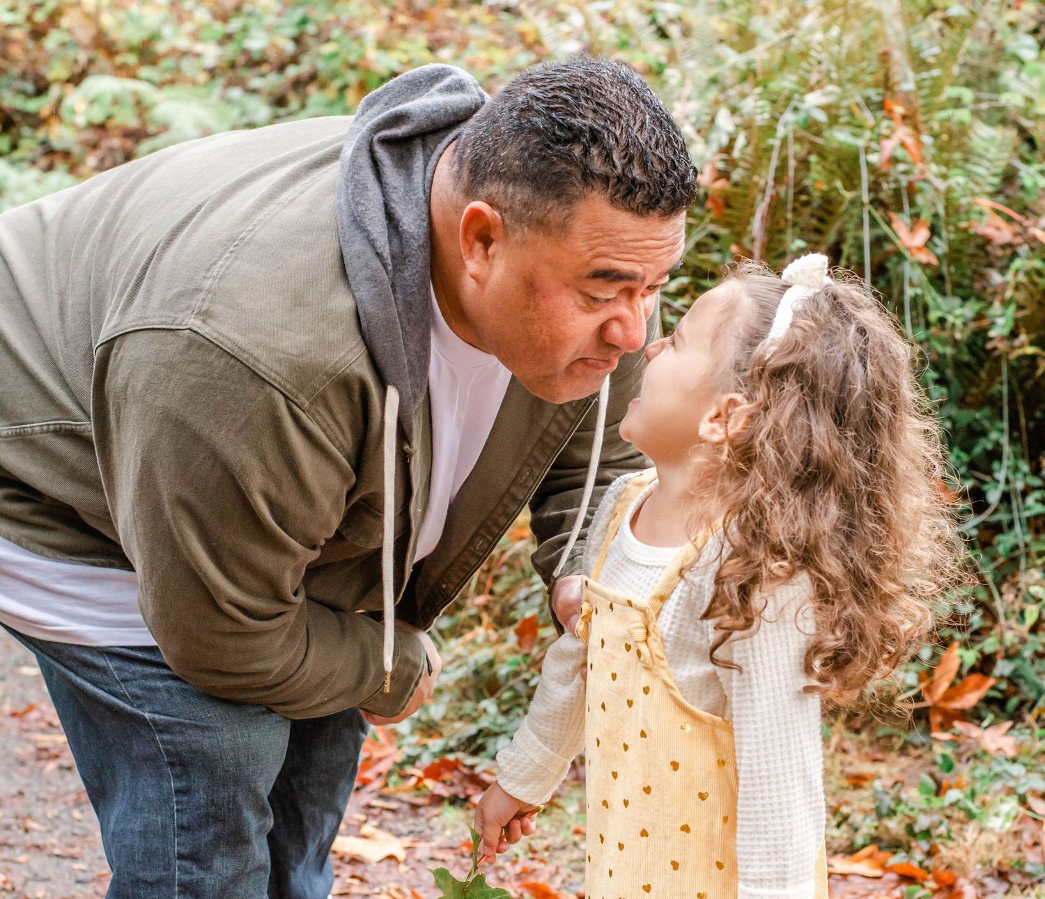 Sweet family interactions captured in natural outdoor setting during fall.