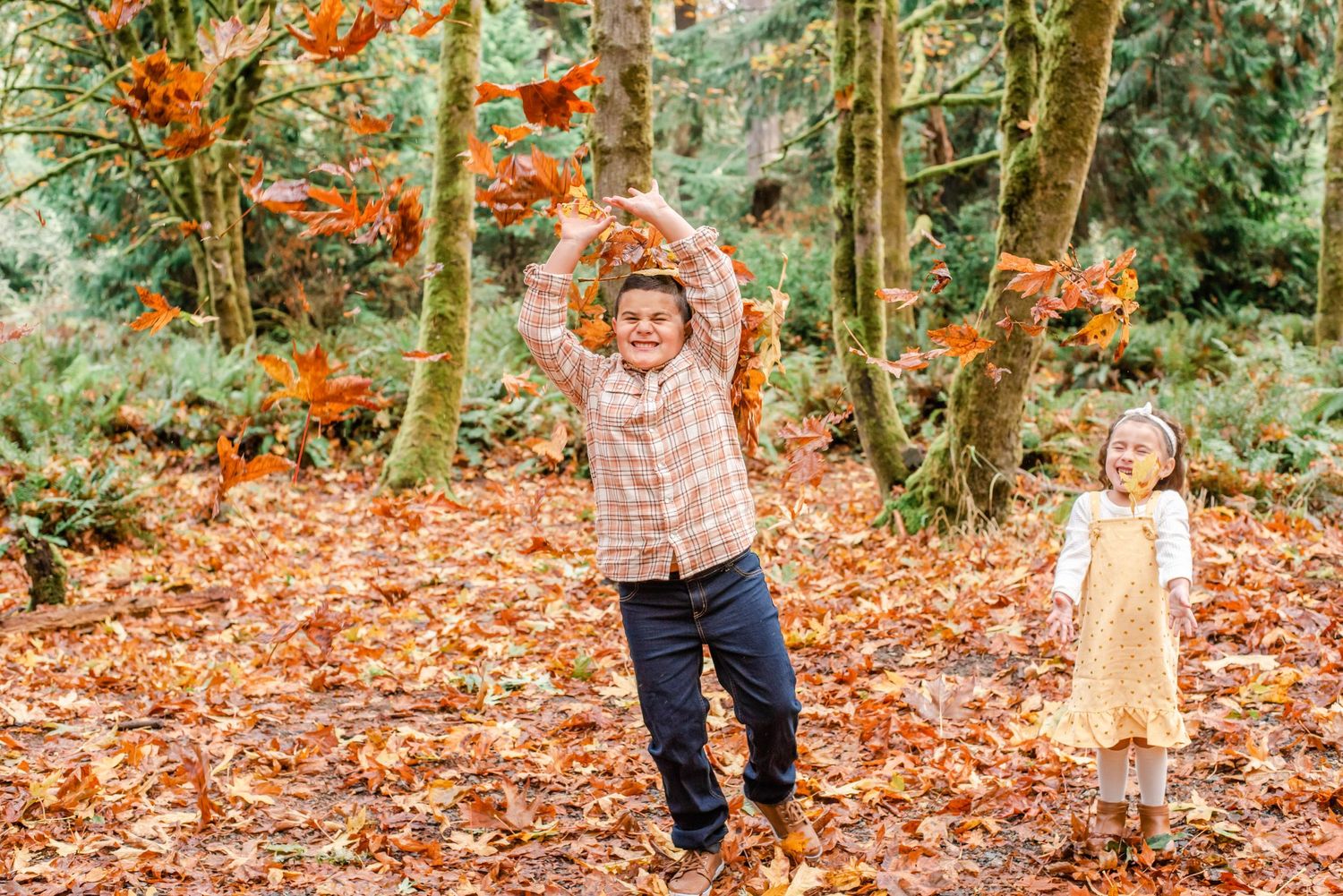 Candid outdoor photography session in a wooded area with vibrant fall colors.