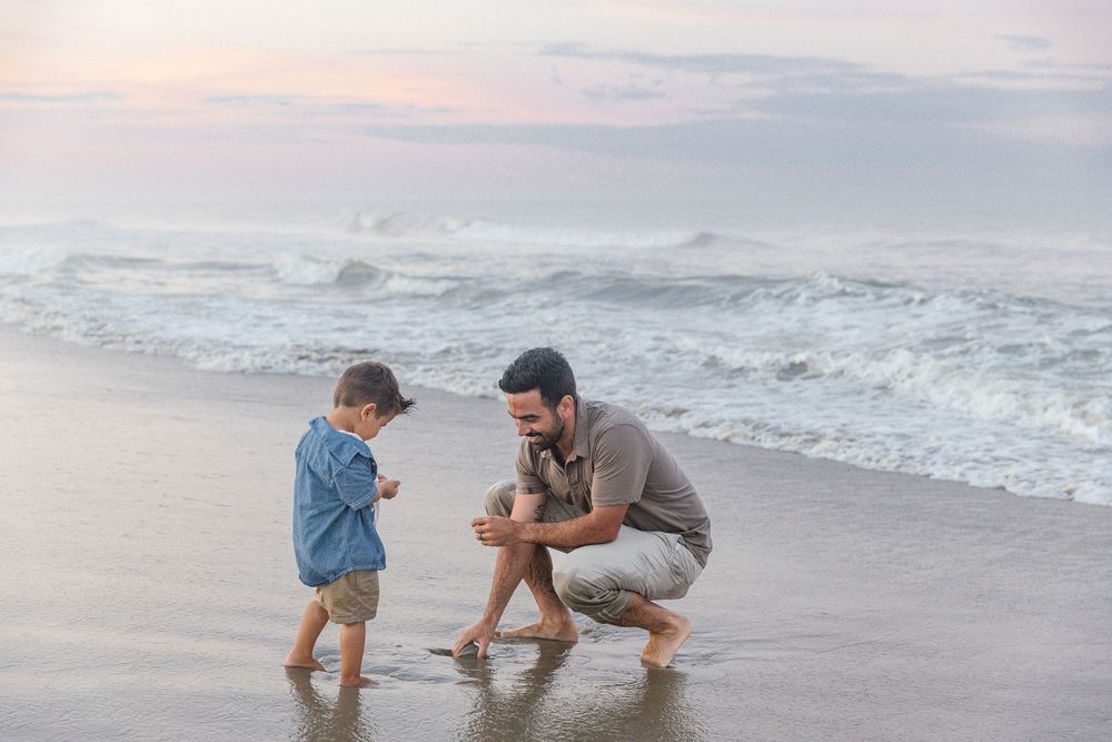 People playing and splashing in ocean waves at sunset.