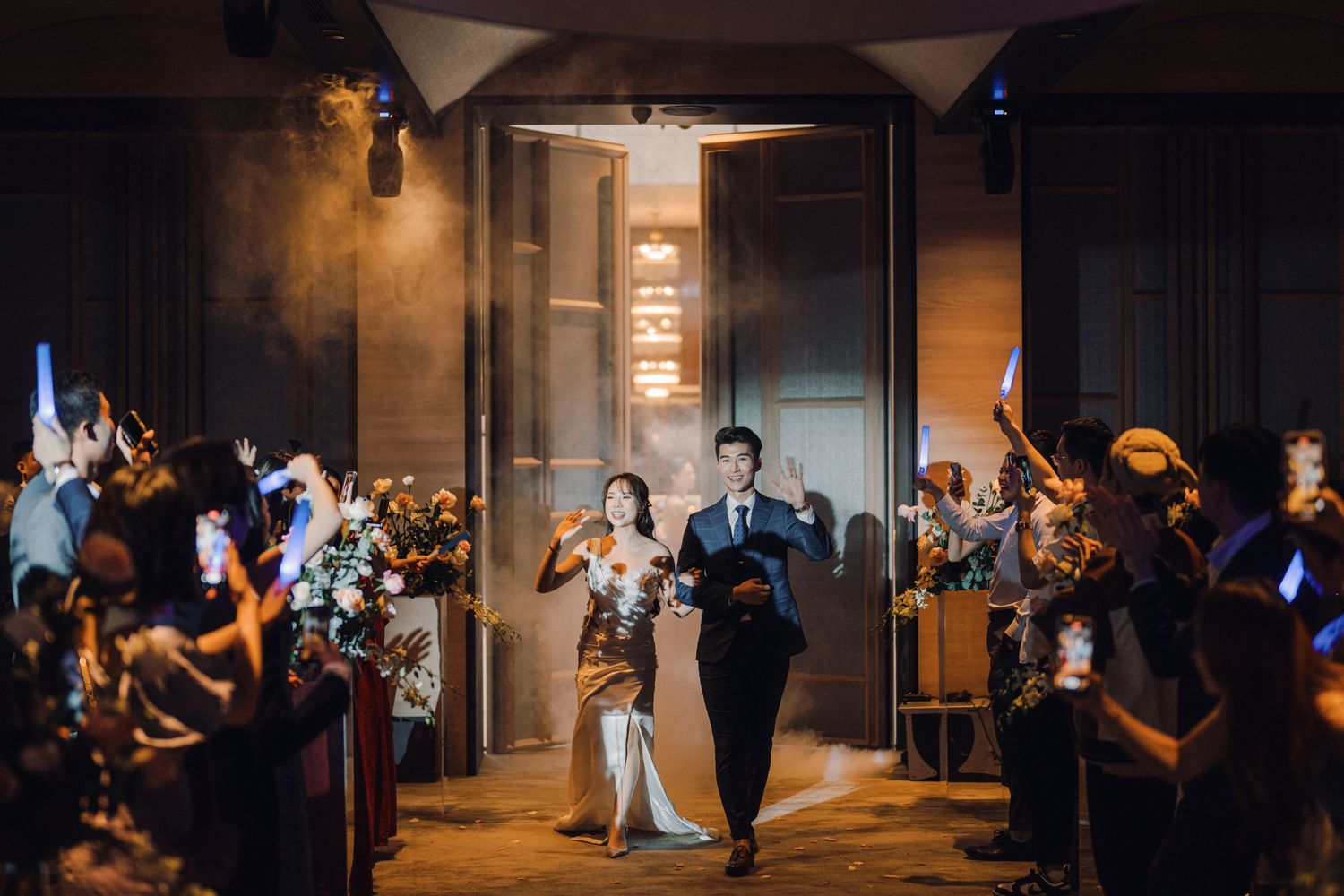 Dramatic low-light wedding reception in an industrial-style venue with ambient lighting.