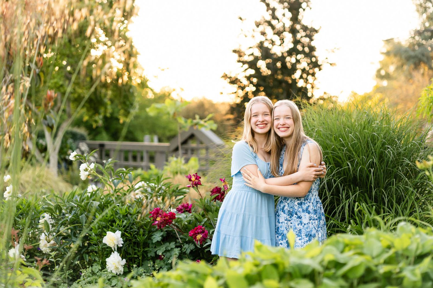 Twin sister smile and hug at the Center for Urban Horticulture.