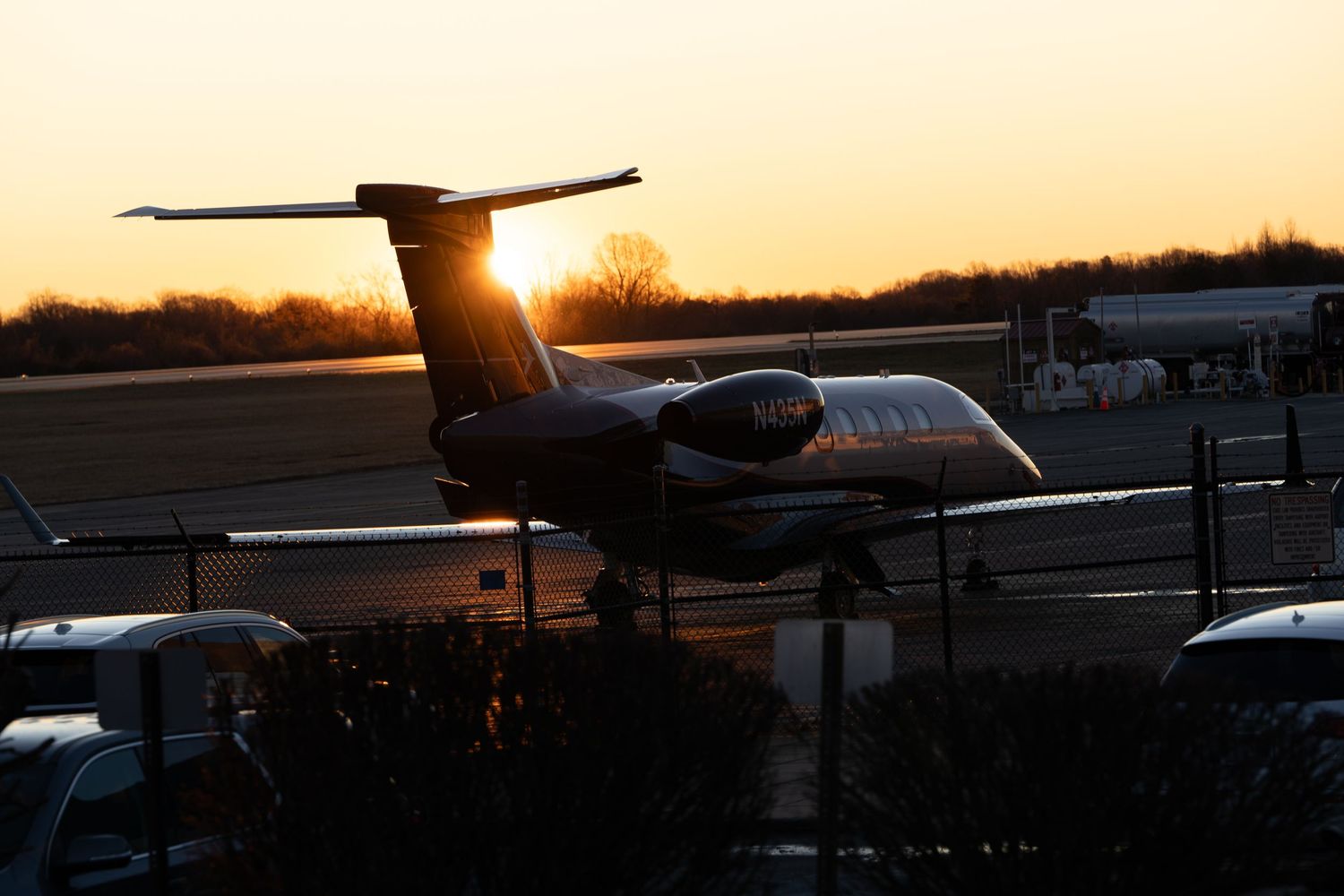 Silhouette of airplane on runway during golden sunset.
