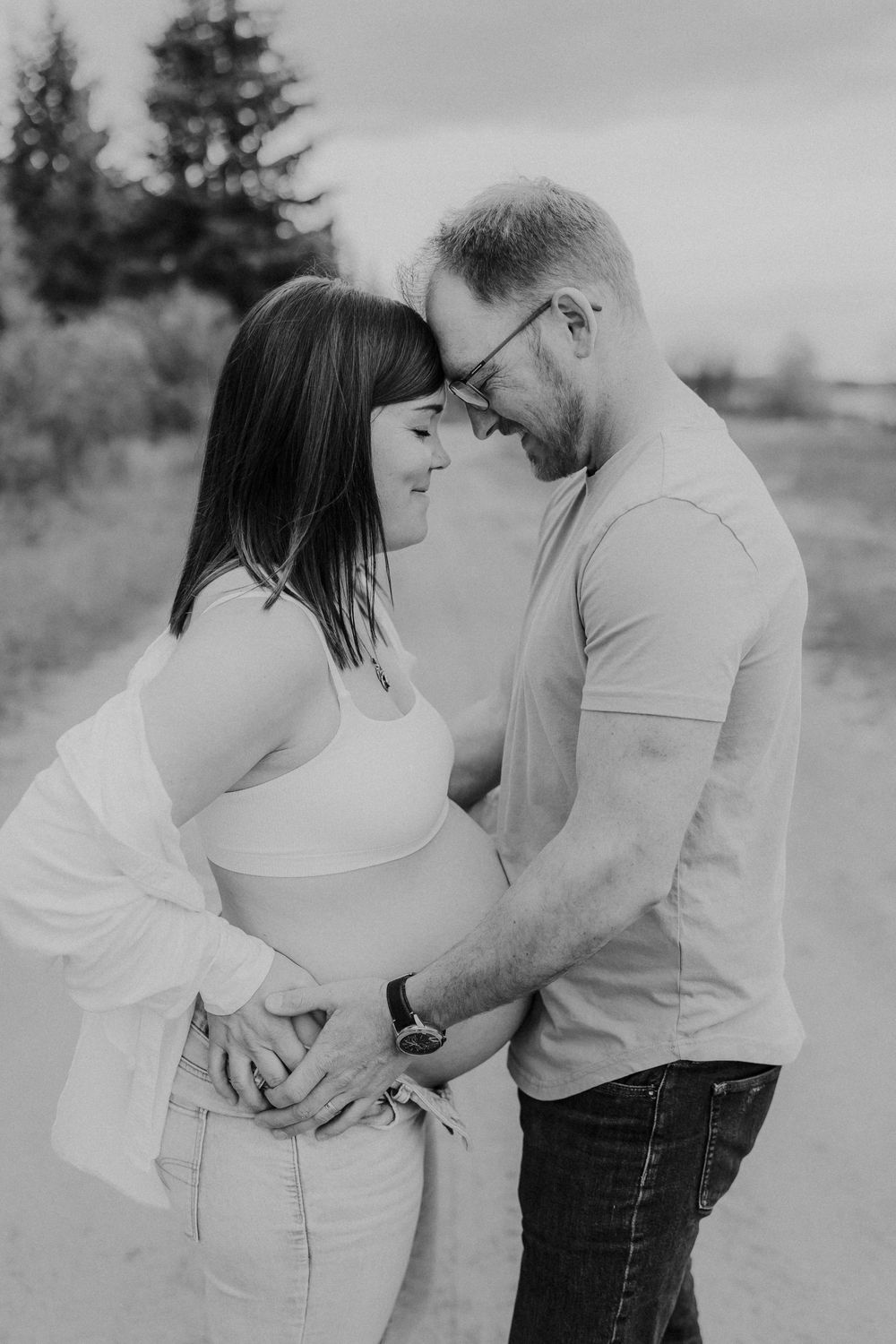 Intimate black and white portrait of couple embracing outdoors.