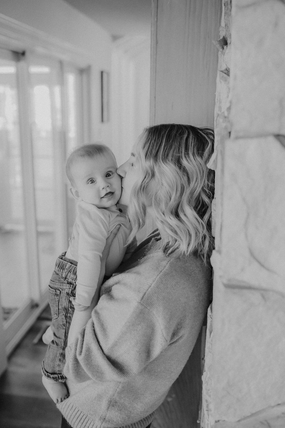 Black and white photo sequence of tender moments against a wall.