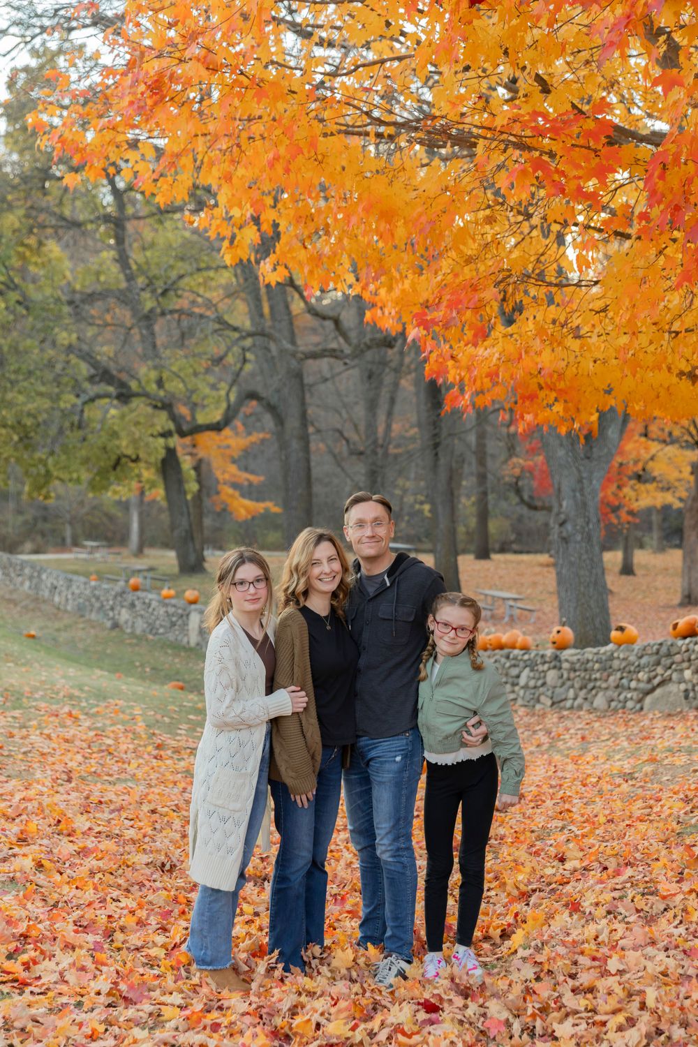 family smiling for a fall photo at van hoosen farm in Rochester Michigan
