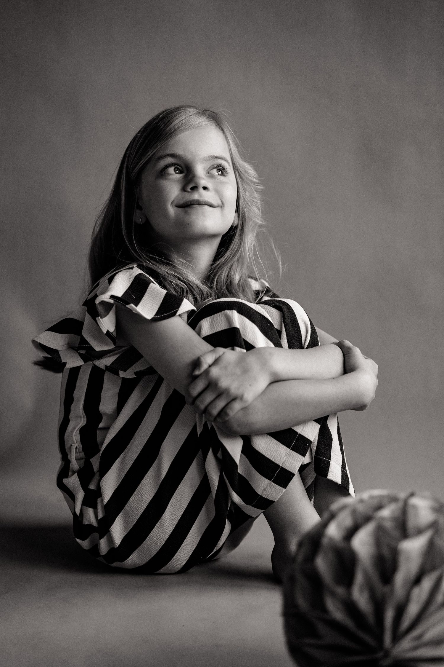 Black and white portrait series showing artistic poses in striped dress on studio floor.