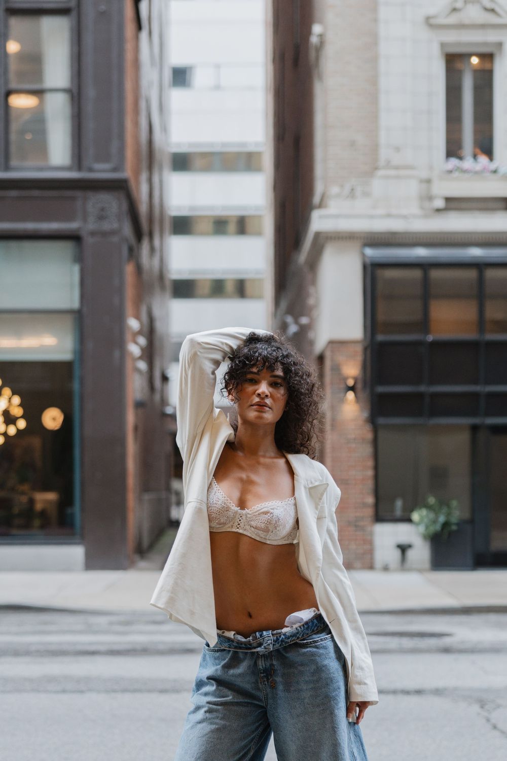 A fashion photo series showing a model in denim and white shirt posing outdoors against an urban backdrop.