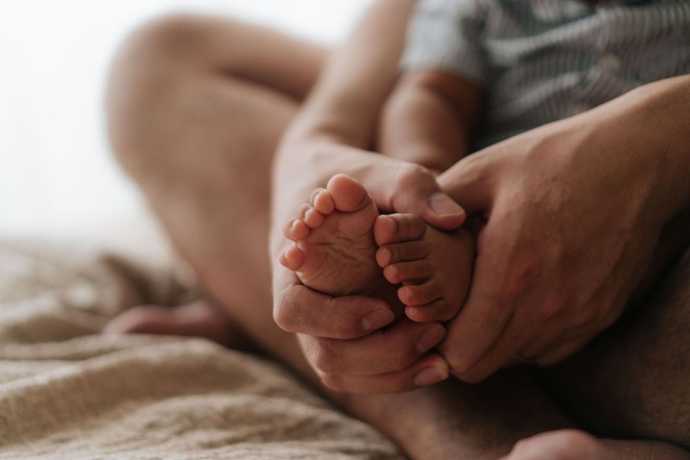 Close-up details of tiny baby feet and gentle hands.