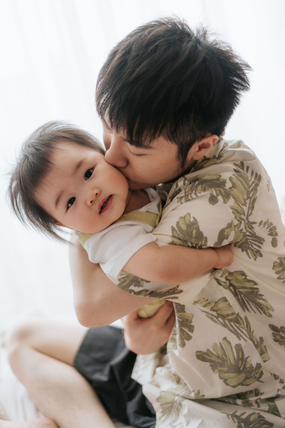 Children playing and embracing in casual wear against bright background.