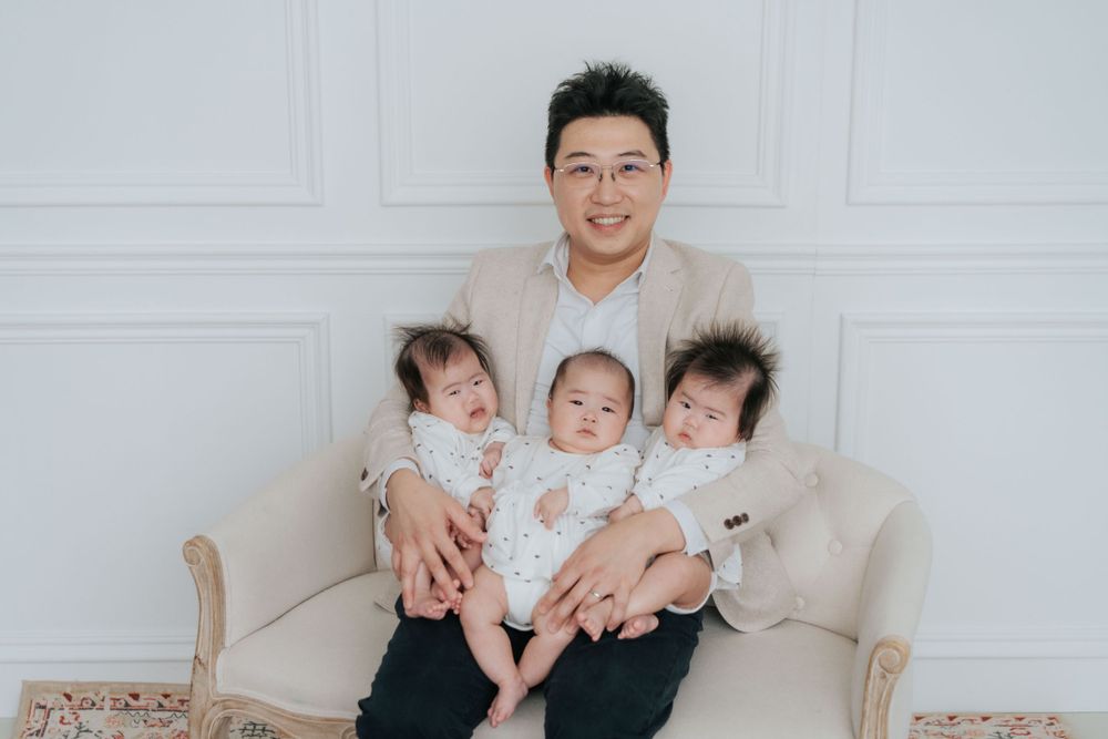 Family portrait session with coordinated outfits against white backdrop.
