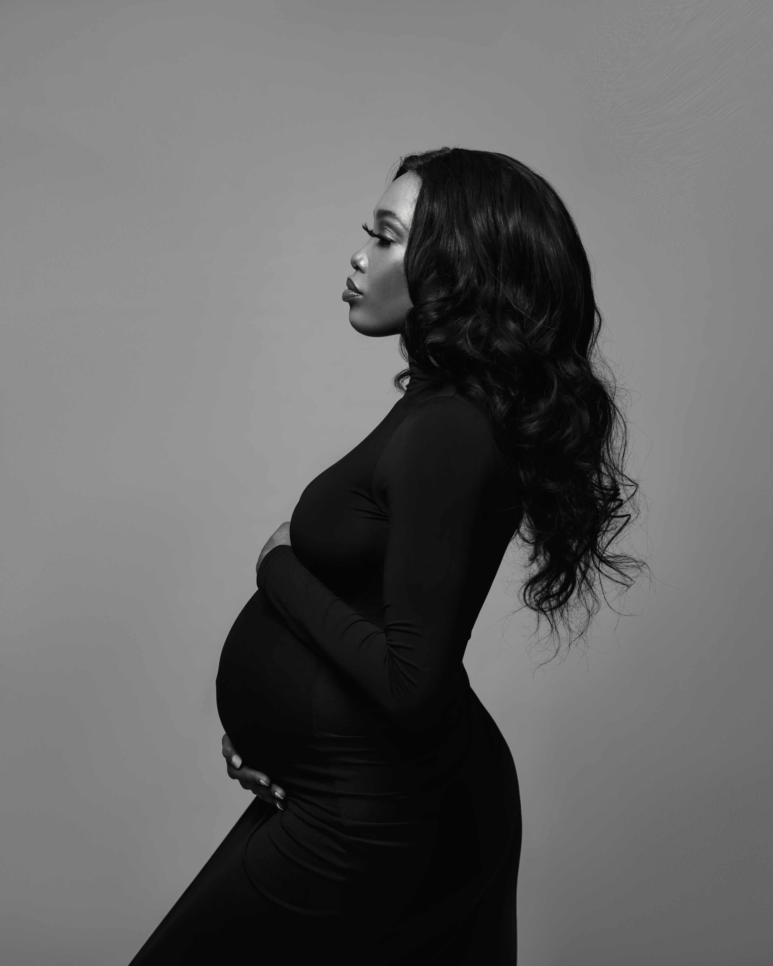 Artistic black and white side profile maternity silhouette showing pregnant belly.