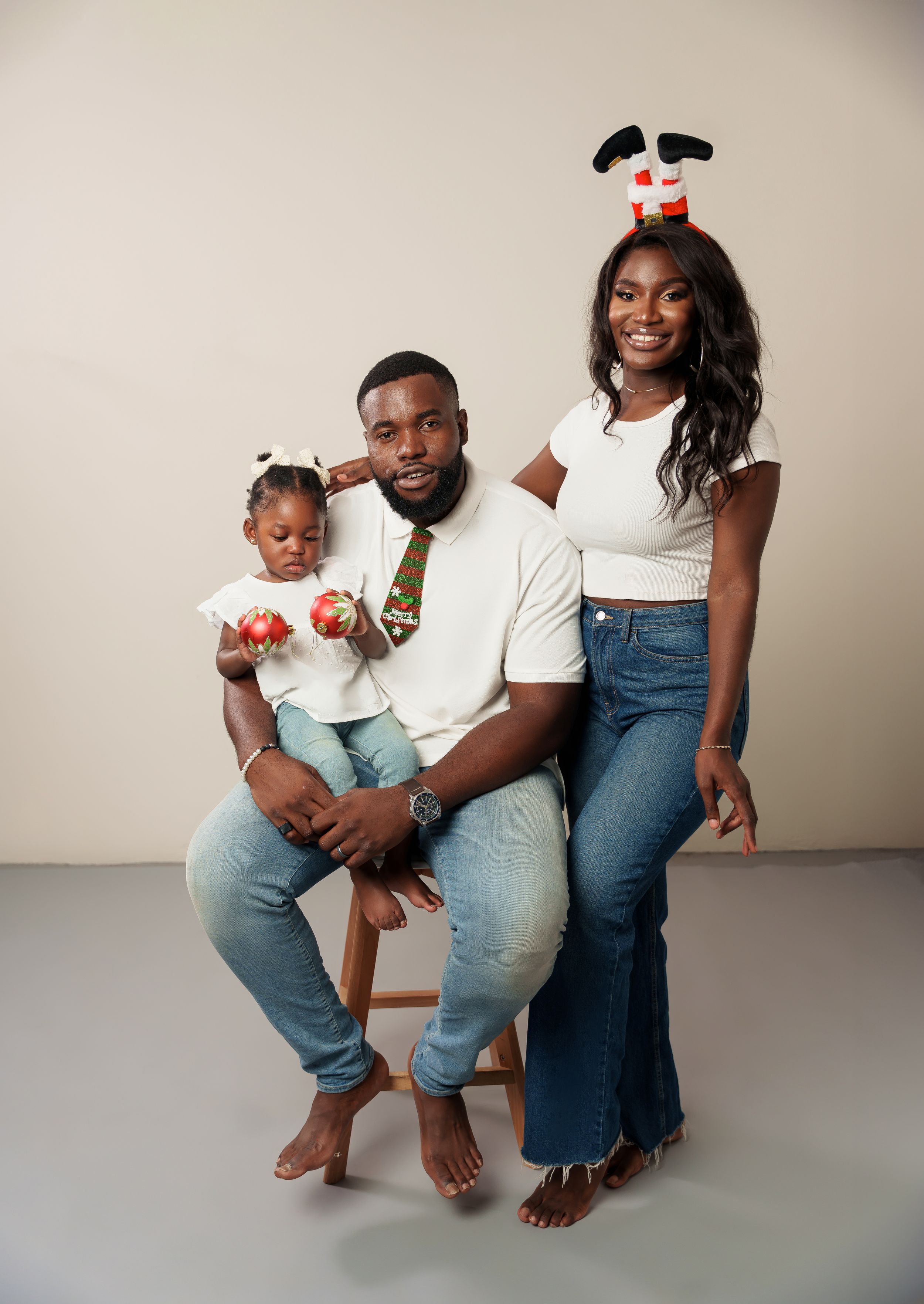 Studio portrait with holiday accessories and coordinated white tops and jeans.