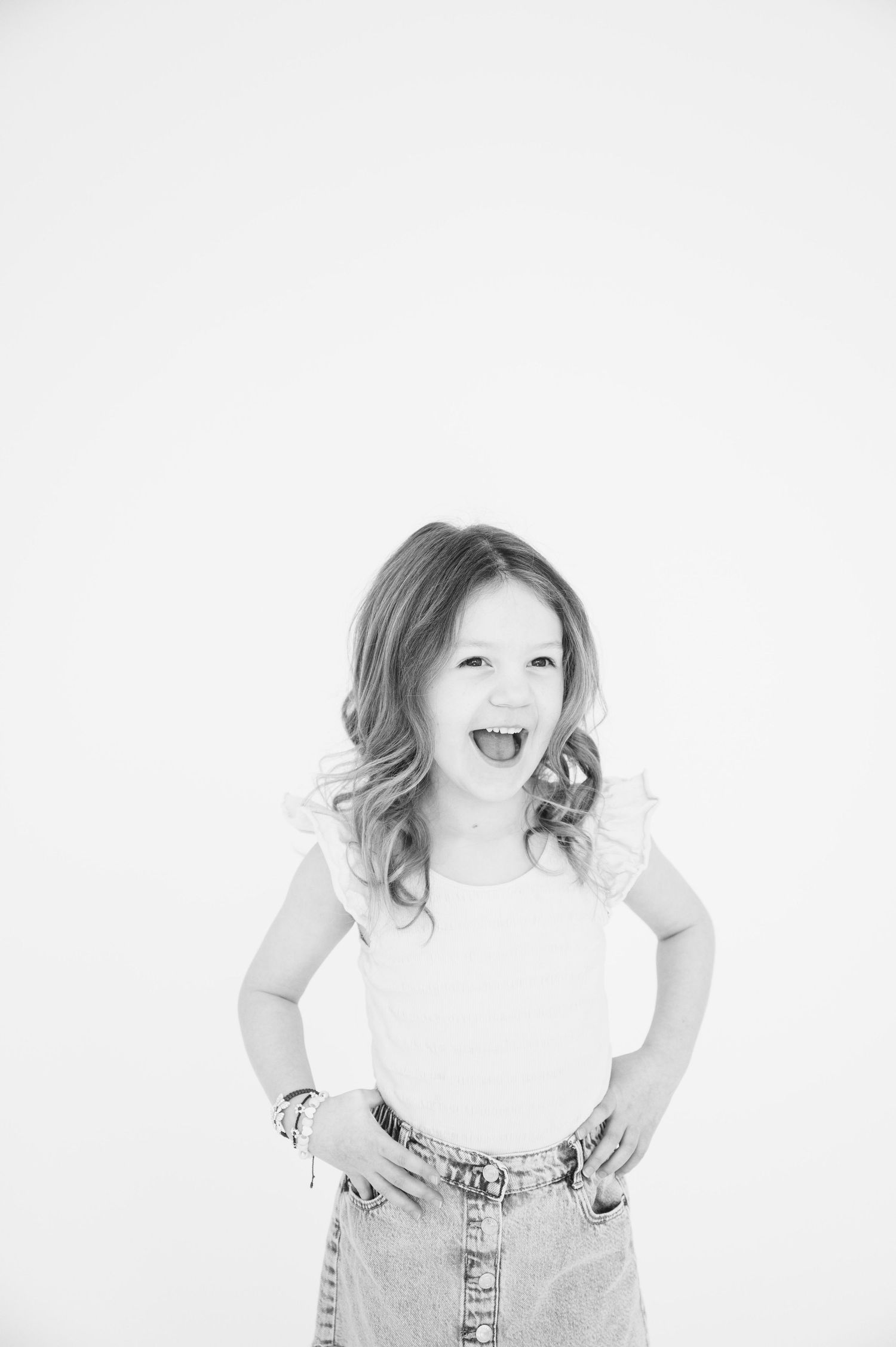 Black and white portrait of girl in casual wear showing energetic expression.
