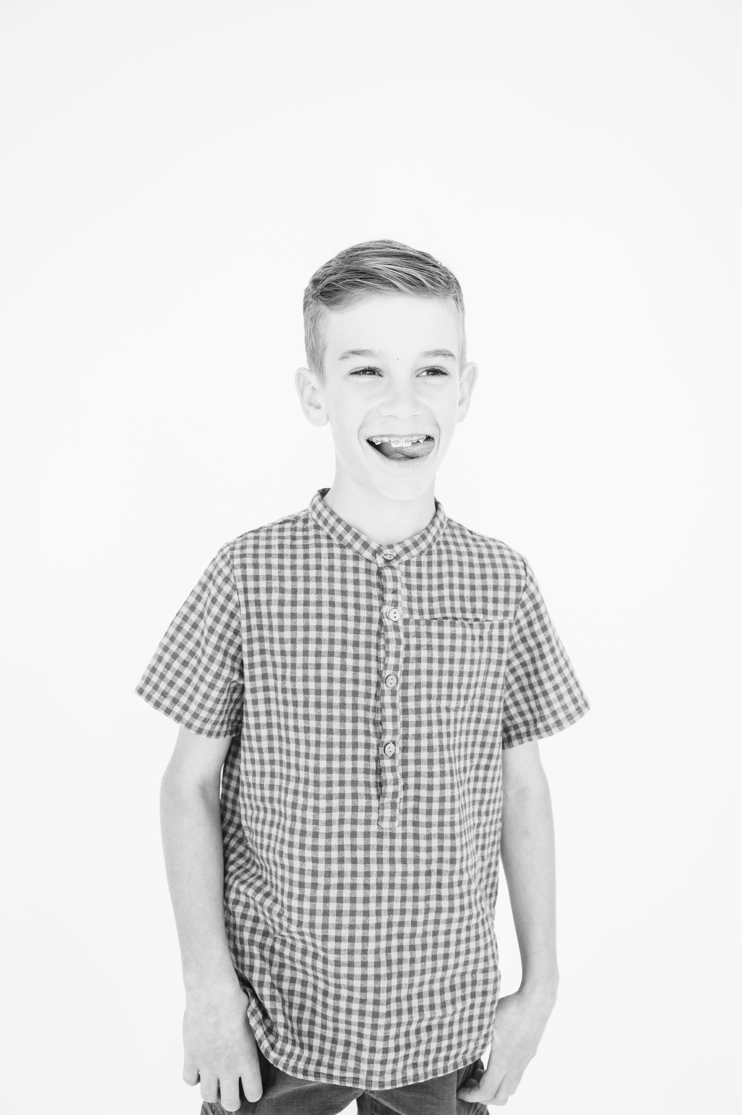 Black and white portrait featuring checkered shirt and casual pose.