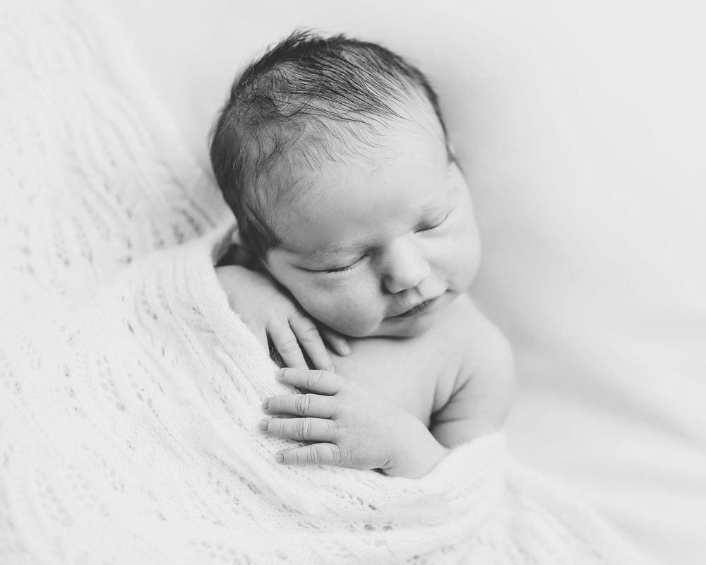 Black and white photograph of a peaceful sleeping newborn baby by Jillian Kennedy