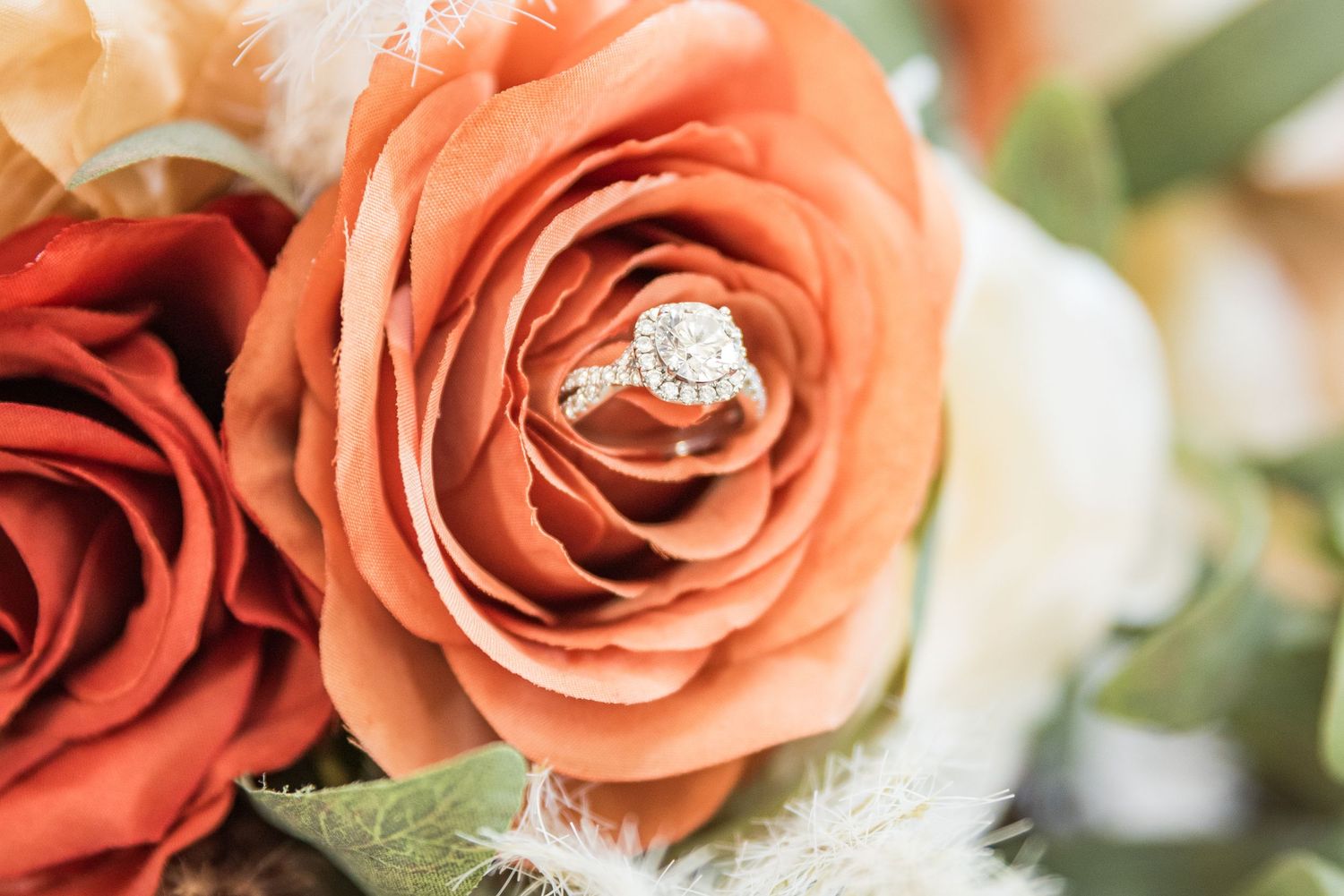 A beautiful wedding ring placed in a floral arrangement.