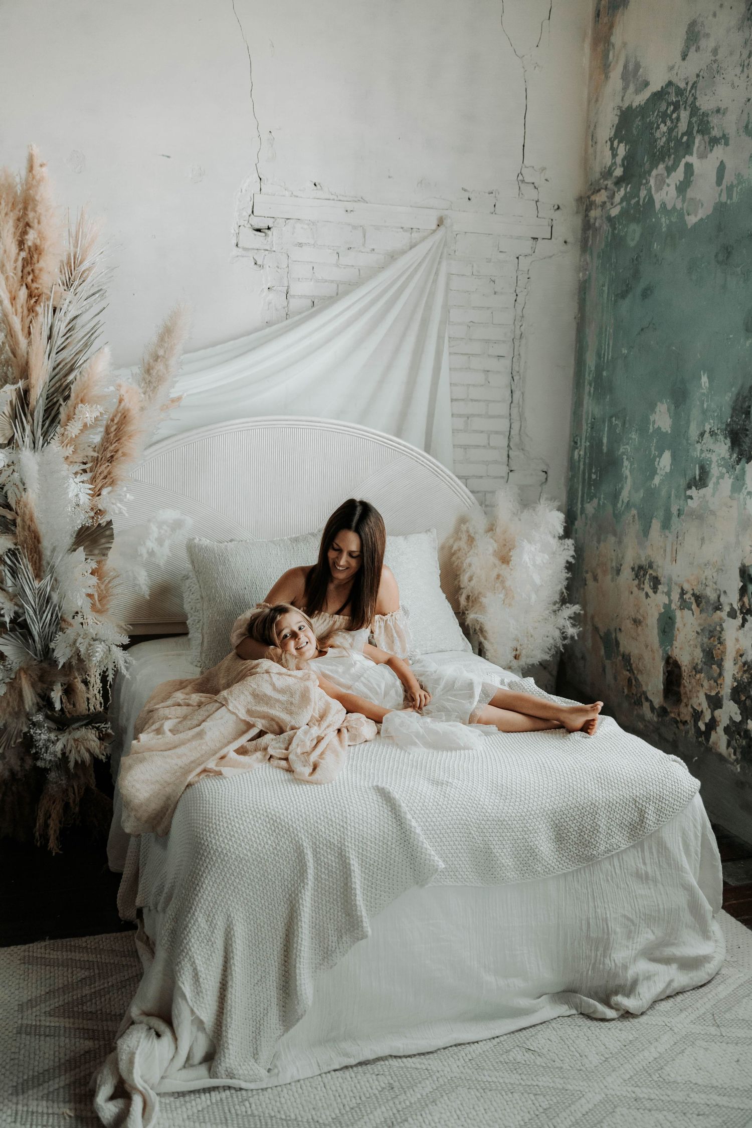 Peaceful nursery scene with pampas grass decor and white bedding in vintage-style setting.
