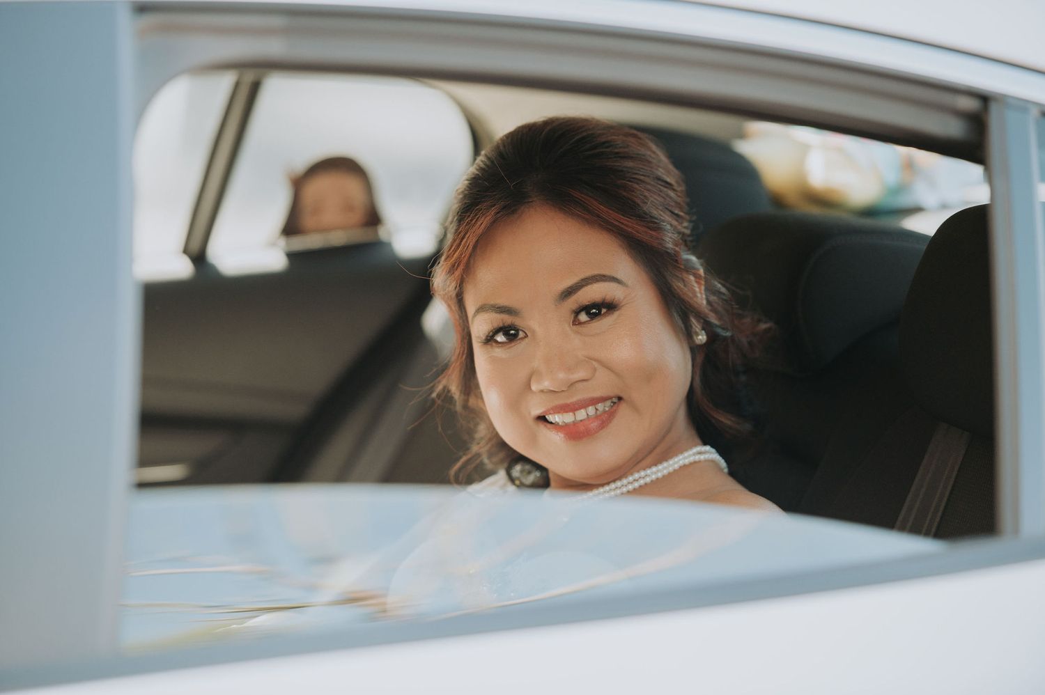 A joyful moment captured through a car window on a wedding day.