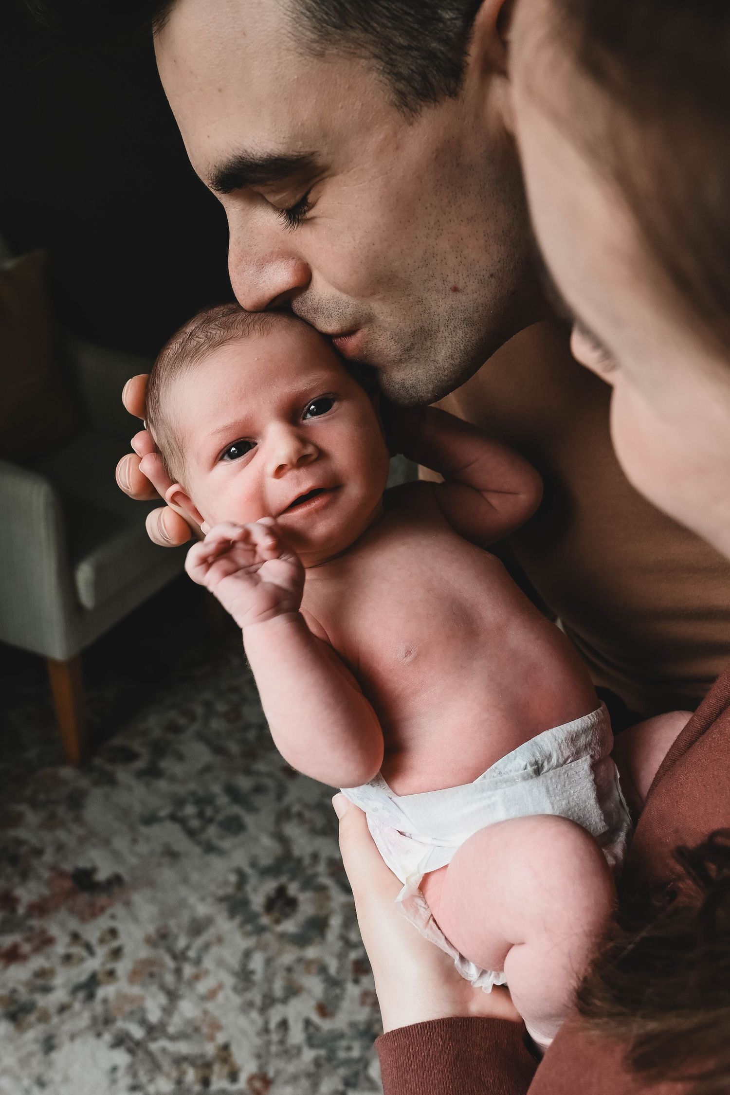 Dad gives baby forehead kiss during newborn session with Krista Manchuck in Albany, NY