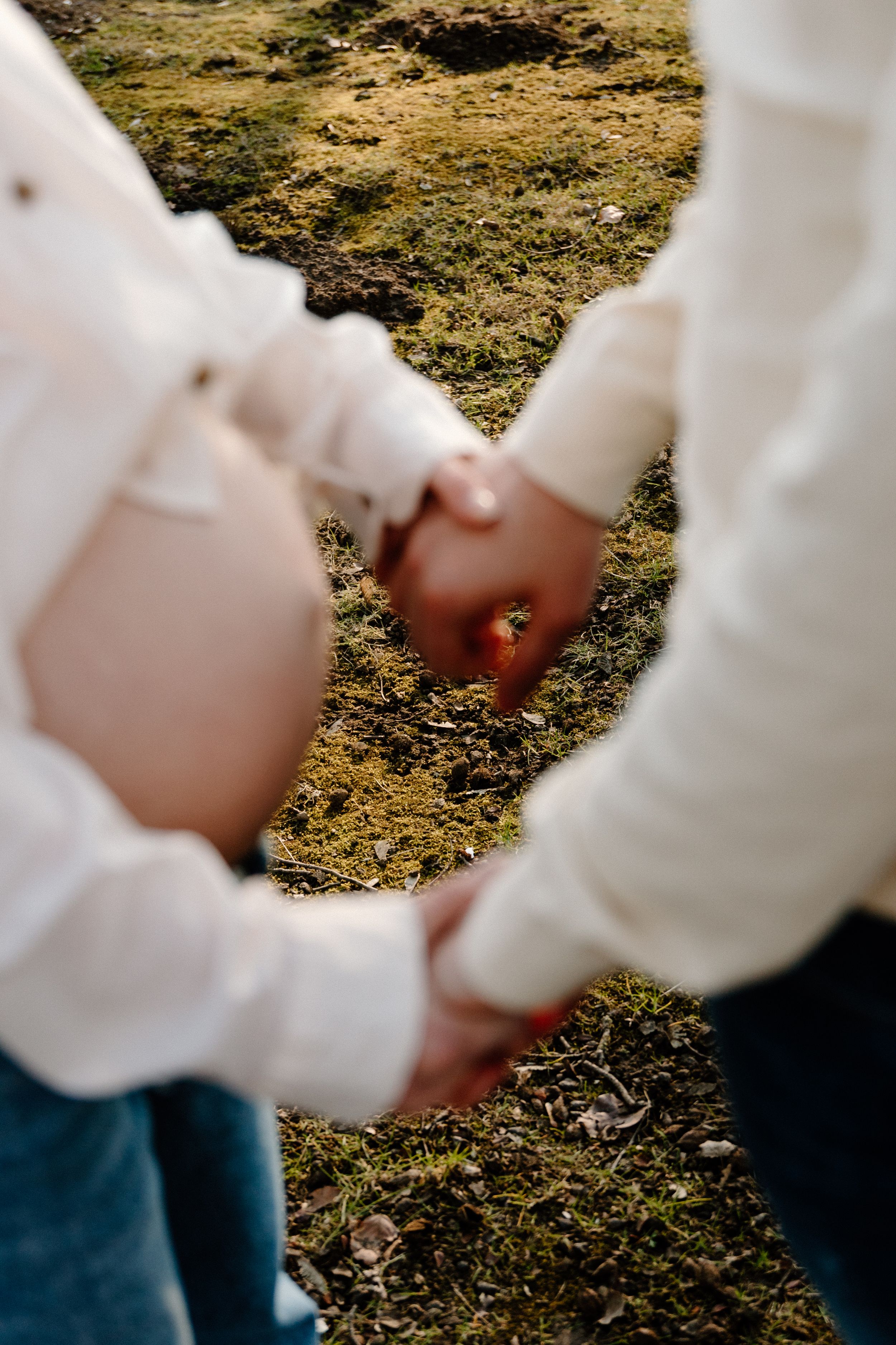 Close-up detail shots of hands and embraces during an outdoor photo session.